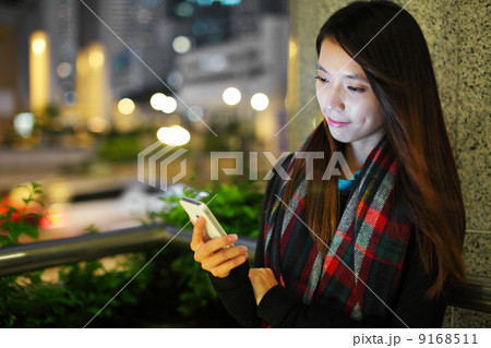 Woman using smartphone in city at night 9168511