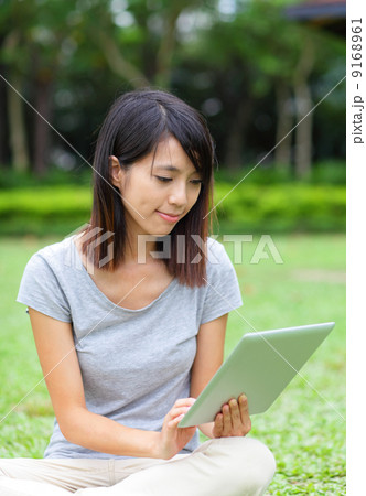 Asian woman looking at computer tablet Asian woman looking at computer tablet 9168961