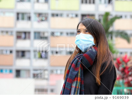 Woman wearing medical face mask in crowded city Woman wearing medical face mask in crowded city 9169039