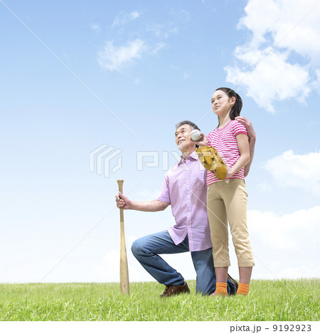 バットとボールを持ち草原に立つ祖父と孫 9192923