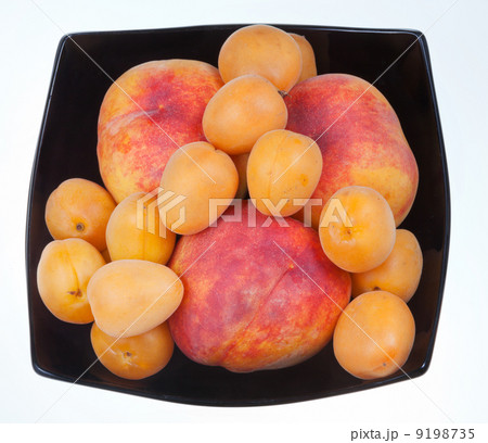 ripe peaches and apricots in black plate 9198735