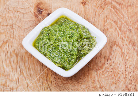 bowl with fresh pesto on wooden board bowl with fresh pesto on wooden board 9198831