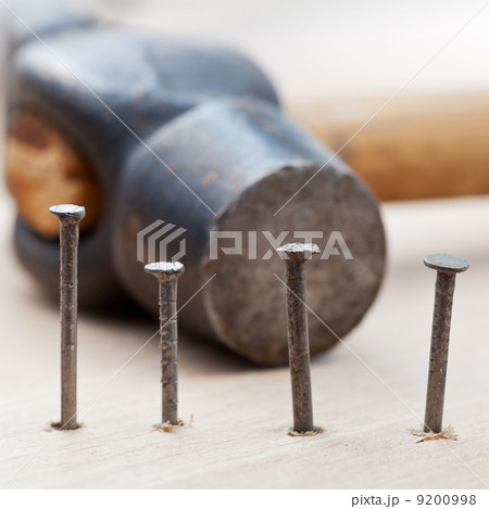 hammer and nails into wooden plank hammer and nails into wooden plank 9200998