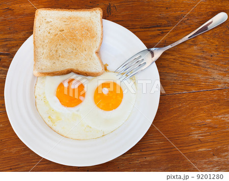 breakfast with two fried eggs in white plate 9201280