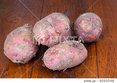 raw pink potatoes on wooden table 9203548