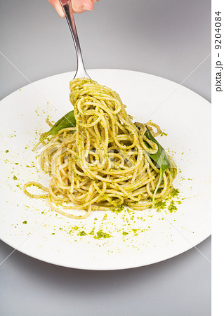 eating spaghetti mixed with fresh pesto 9204084