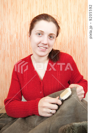 Woman cleaning a sheepskin with whisk broom Woman cleaning a sheepskin with whisk broom 9205592