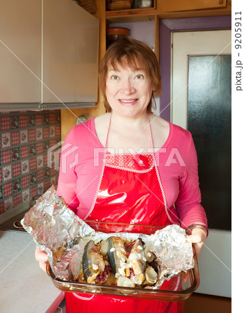 Woman with cooked scomber Woman with cooked scomber 9205911