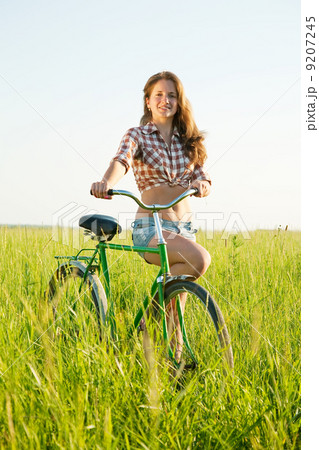 girl riding bicycle in grass girl riding bicycle in grass 9207245