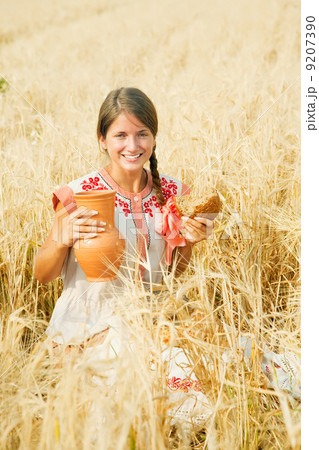 Girl with bread at cereals field 9207390
