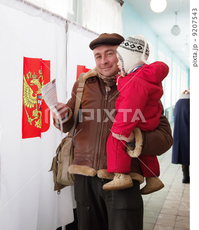 Man with child votes in Russian presidential election 9207543