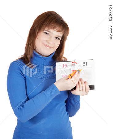 Girl is marking a day on one's diary Girl is marking a day on one's diary 9207758