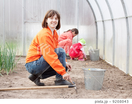 family sows seeds in soil 9208043