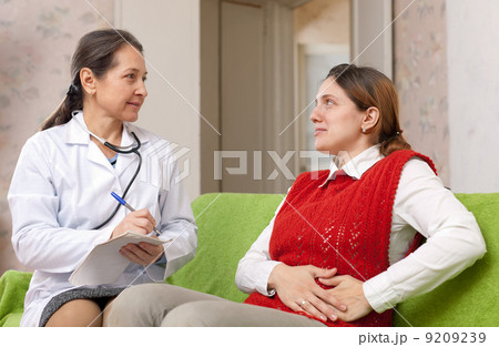 woman complaining of pain in side to doctor woman complaining of pain in side to doctor 9209239