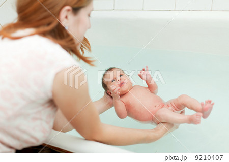 Mother bathes newborn baby Mother bathes newborn baby 9210407