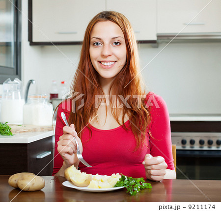 Happy woman in red eating jacket potatoes Happy woman in red eating jacket potatoes 9211174