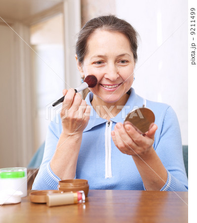 woman putting facepowder on face 9211499