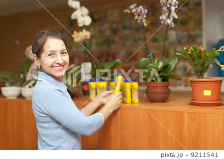 woman chooses liquid fertilizer at store 9211541