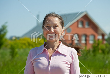 Happy woman against her home 9211542