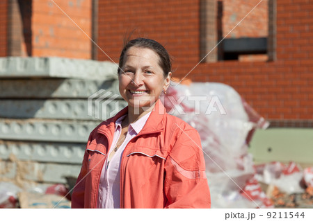 Happy mature woman against building residence 9211544