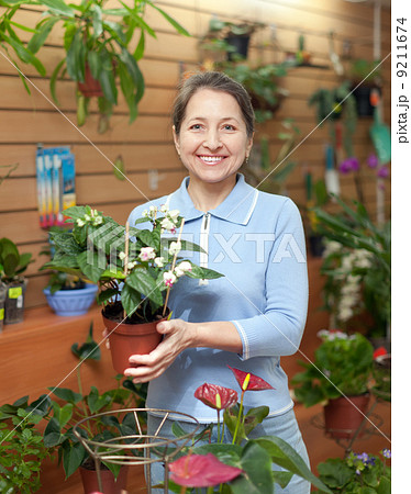 Happy mature woman in flower store Happy mature woman in flower store 9211674
