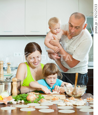 parents with children dumplings fish cooking in a home kitchen 9212533