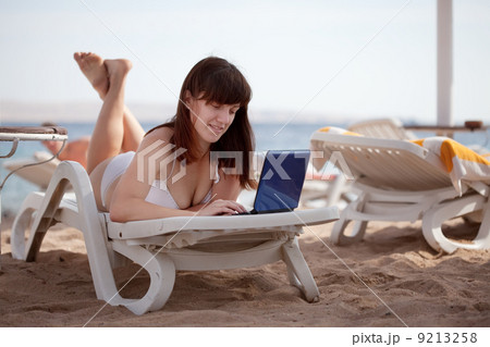 woman using laptop at resort beach 9213258