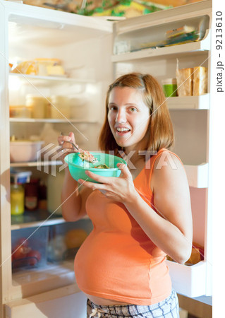 pregnant woman eats from fridge 9213610