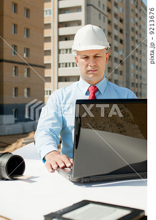 Architect works in front of building site 9213676