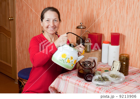 Mature woman brews herbs Mature woman brews herbs 9213906