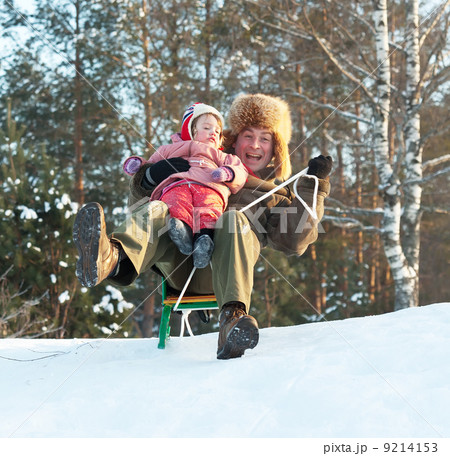 Happy man with child sliding on sleds 9214153
