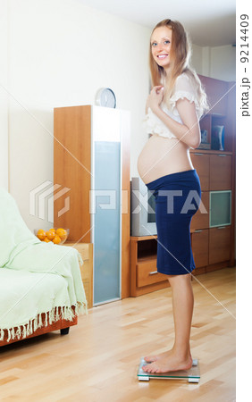 Happy pregnancy woman on bathroom scale 9214409