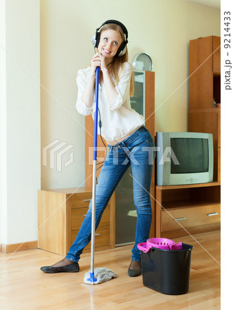 Smiling woman washes the floor with mop Smiling woman washes the floor with mop 9214433