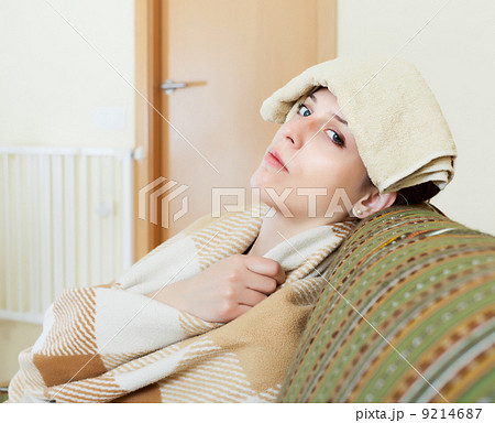 woman having headache holding towel 9214687