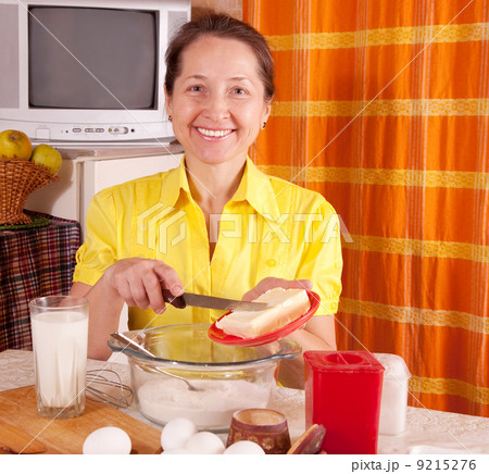woman adds margarine into dough woman adds margarine into dough 9215276