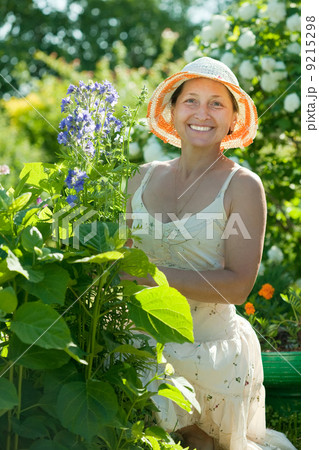 Mature woman in Campanula plant 9215298