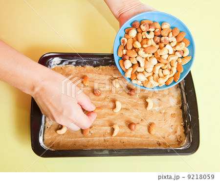 woman adds nuts into dough woman adds nuts into dough 9218059