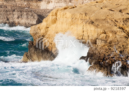 wave breaking against cliff 9218397