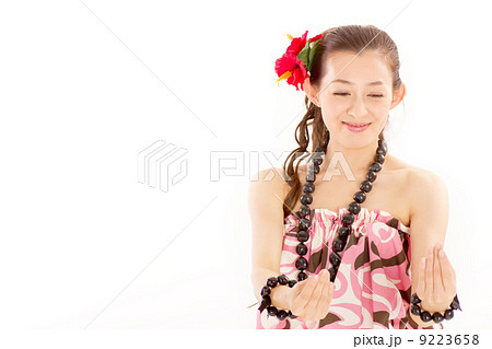ハワイの民族衣装を着てフラを踊る優しそうな笑顔の女性の写真素材