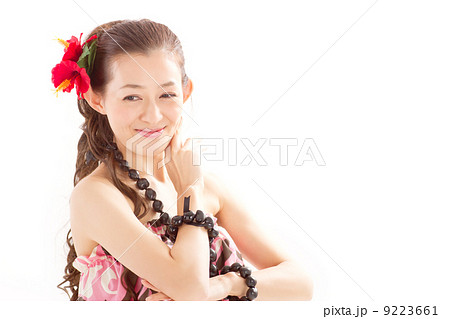 ロングヘアに大きなハイビスカスが華やかなフラダンスを踊る綺麗な女性の写真素材