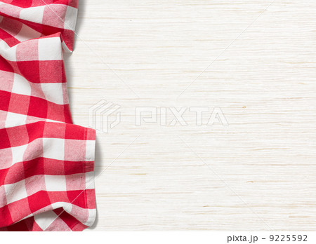 red folded tablecloth over bleached wooden table red folded tablecloth over bleached wooden table 9225592