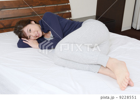 ベッドに横になる若い女性 9228551