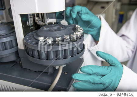 Centrifuge with experiment tubes and hands in gloves 9249216