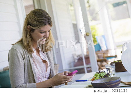A woman sitting at a table using a smart phone. 9251132