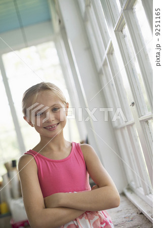 A young girl in a kitchen wearing a pink dress. A young girl in a kitchen wearing a pink dress. 9251165
