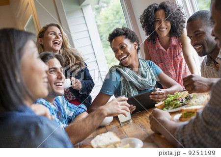 A group of people meeting in a cafe for a meal. Using digital tablets and smart phones. A group of people meeting in a cafe for a meal. Using digital tablets and smart phones. 9251199