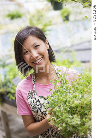 Working on an organic farm. A woman tending young plants in a glass house. Working on an organic farm. A woman tending young plants in a glass house. 9251206
