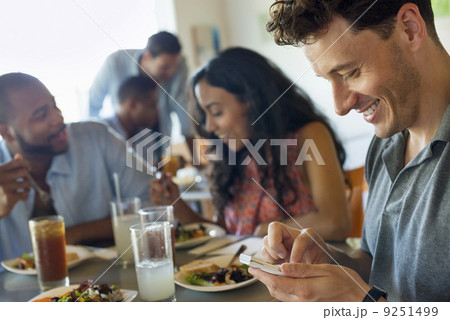 A group of men and women in a cafe, having drinks and enjoying each other's company. A group of men and women in a cafe, having drinks and enjoying each other's company. 9251499