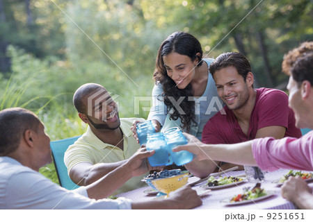 A group of people having a meal outdoors, a picnic. Men and women.  9251651