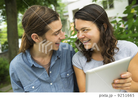 A young couple side by side, flirting and taking photographs. A young couple side by side, flirting and taking photographs. 9251665